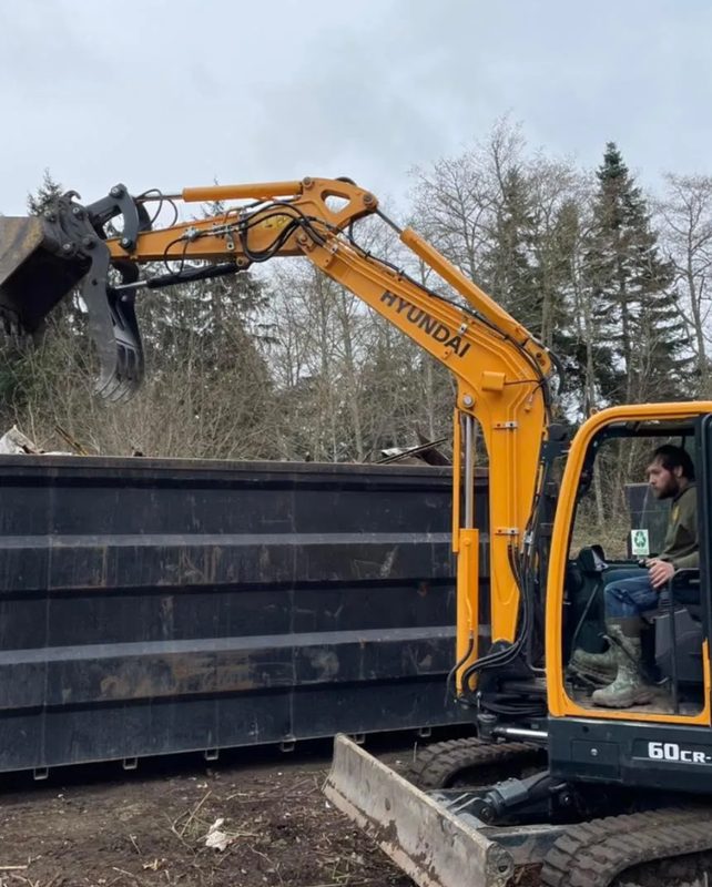 Excavator loading debris into a trailer